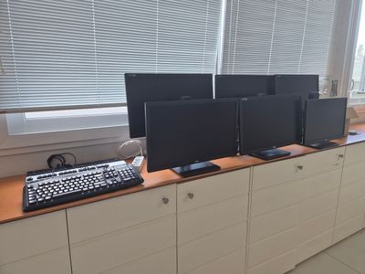 four computer monitors and a keyboard on a desk