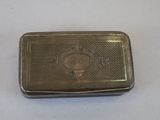 an old silver cigarette case with a picture of a man on it