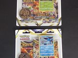 deux paquets de cartes à collectionner Pokémon posés sur une surface noire