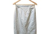 a white skirt hanging on a wooden hanger on a white wall