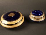 deux boîtes bleues et dorées posées sur une surface noire
