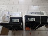 two toasters sitting on a tiled floor next to each other
