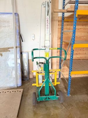 un diable vert avec une poignée jaune dans un garage