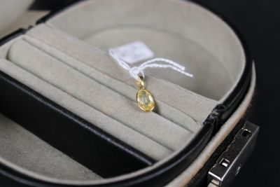 a ring in a case with a yellow stone