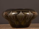 a black and white vase sitting on a wooden table