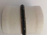 a close up of a bracelet with black and white diamonds on it