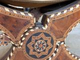 a close up of a wooden table with a circular design on it