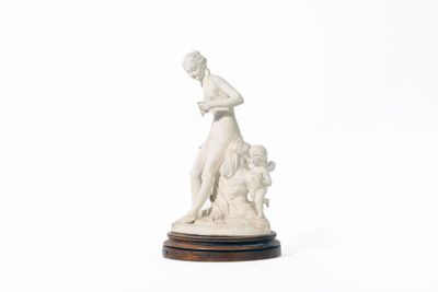 une statue représentant une femme avec un chien, posée sur un socle