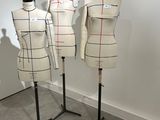 three mannequins are lined up on a stand in a room