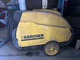 une machine jaune qui se trouve à côté d'un tas de pneus