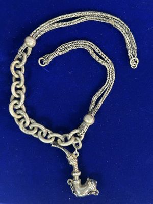 un collier en argent avec une breloque en forme d'ancre suspendue à une chaîne