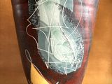 a vase with a painting on it sitting on a table