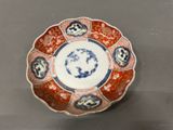 an orange, blue and white plate with flowers on it