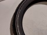 a close up of a tire on a white surface with a person ' s hand holding it