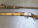 two old weapons are sitting on a table next to each other