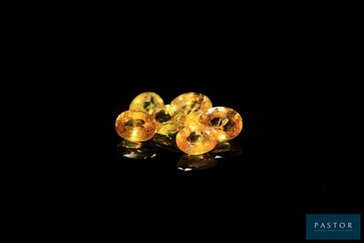 a pair of yellow sapphires sitting on top of a black surface