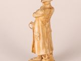 statue of a man in a trench coat and hat holding a cane