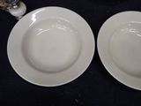 two white plates on a black table with silverware