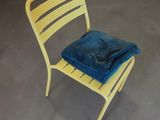 une chaise jaune recouverte d'une couverture bleue