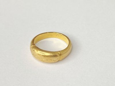 a close up of a gold ring on a white surface