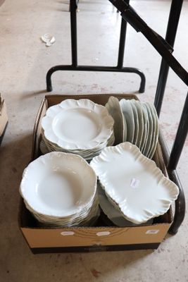 many plates and bowls in a box on the floor