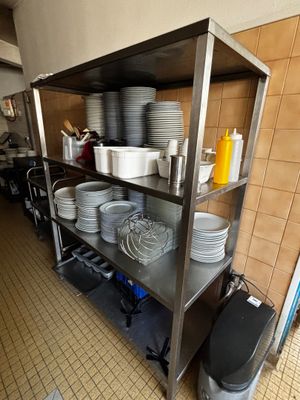 beaucoup d'assiettes et de casseroles sur les étagères de la cuisine