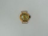 a small gold watch on a white surface