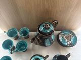 a lot of teapots and cups sitting on a table