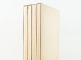 three books stacked on top of each other on a white surface