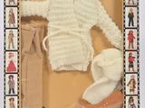 une poupée dans une boîte, avec un pull et des chaussures