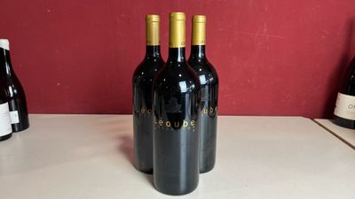 trois bouteilles de vin posées les unes à côté des autres sur un comptoir