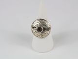 un gros plan d'une bague en argent sertie d'une pierre marron