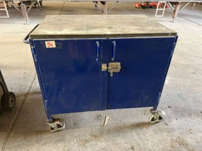 a blue cabinet with two doors on wheels in a room