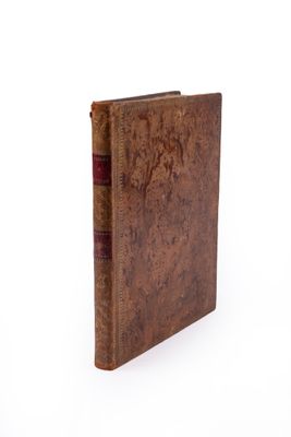 an old book sitting on top of a white table next to a white wall