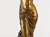 statue en bronze représentant une femme tenant un club de golf, posée sur un socle en marbre