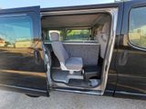 a black van with its doors open and a seat in the back