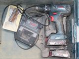 a box with a drill and other tools inside of it