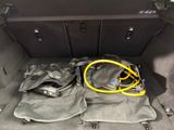 a bag and a hose in the trunk of a car
