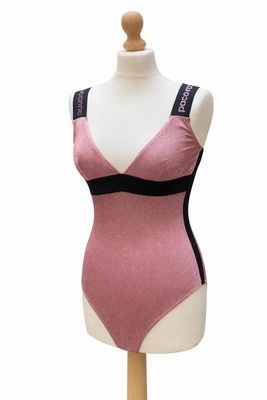 maillot de bain une pièce rose et noir posé sur un socle de mannequin