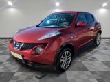 Une Nissan Juke rouge est garée dans une pièce dont le sol est en damier.