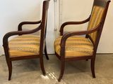 two wooden chairs with striped upholstered seats in a room