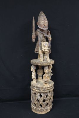 a wooden statue of a man holding a knife on top of a table