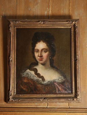 portrait d'une femme en robe marron dans une pièce aux murs lambrissés