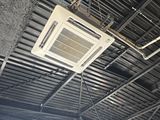 a ceiling mounted air conditioner hanging from the ceiling