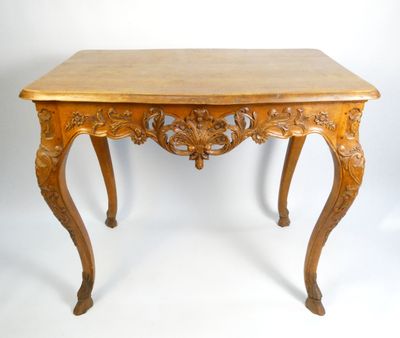 une table en bois dont le plateau est sculpté, sur fond blanc
