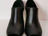 the back view of a pair of black leather shoes on a white surface