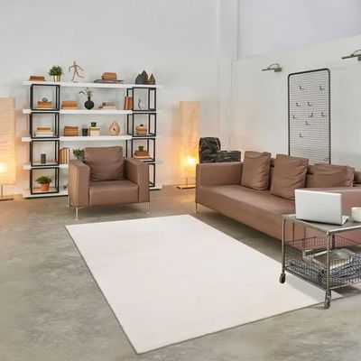 a living room with a couch, chair, table, and bookshelf