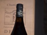 a bottle of wine sitting on a table next to a book