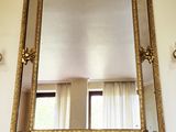un miroir accroché au mur au-dessus de la cheminée du salon