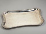 a silver plate with a curved edge on a gray surface